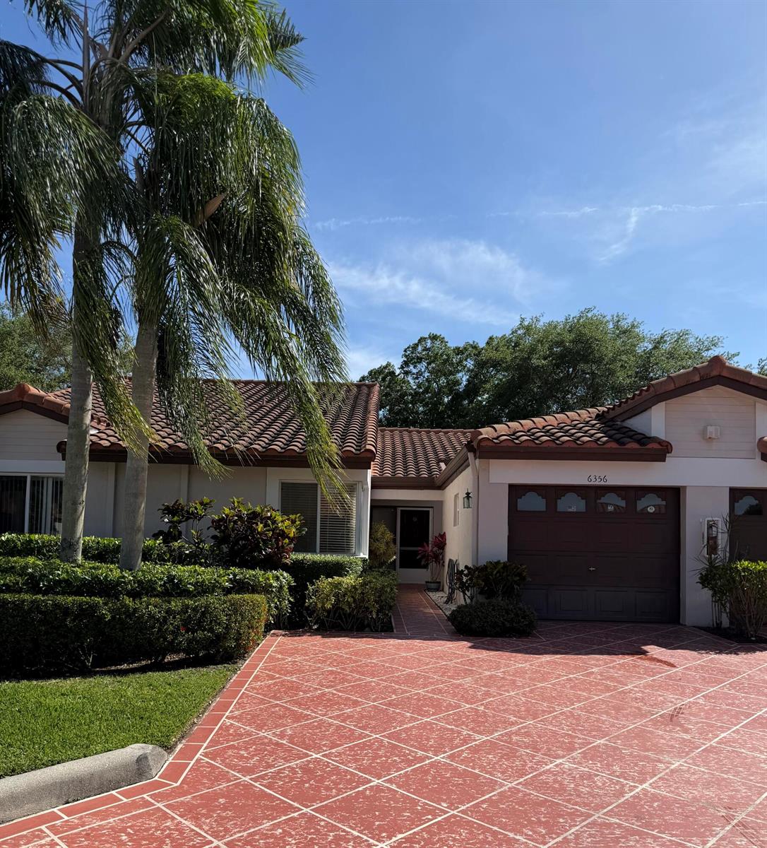 A single-story house with a red tile roof, brown garage door, and patterned driveway — 6356 Pointe Pleasant Circle, Delray Beach FL 33484, DELRAY BEACH, FL