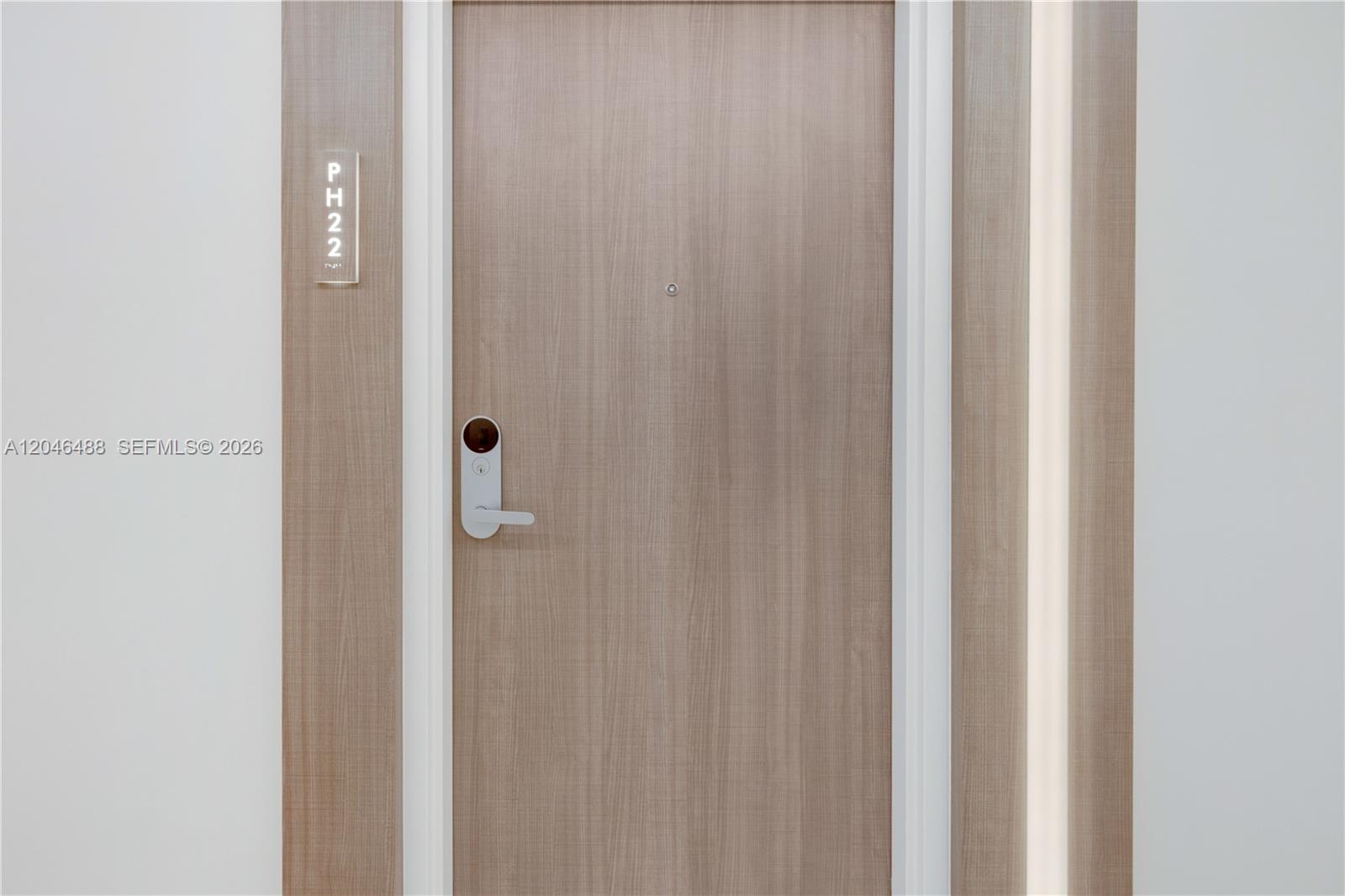 A light wood-grain door features a modern electronic lock and a unit number sign — 2301 Collins Ave, Miami Beach FL 33139, MIAMI BEACH, FL