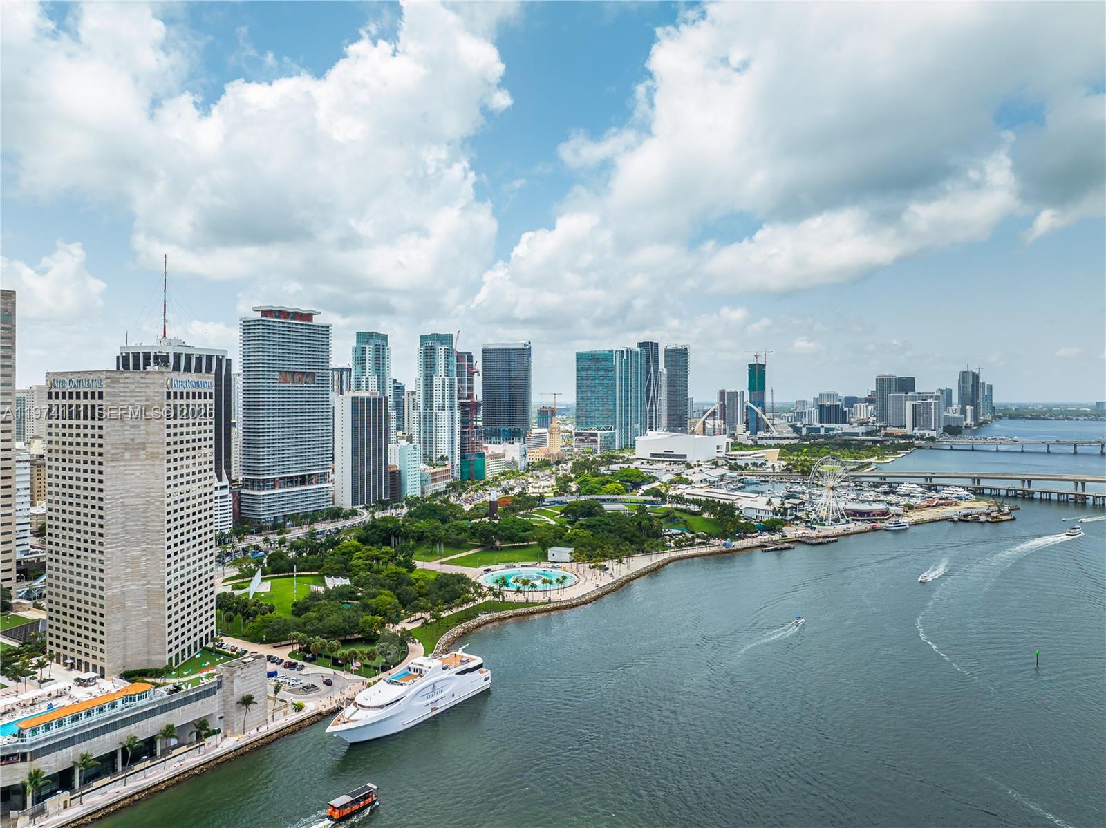 An aerial view of the Miami skyline featuring a large park, waterfront, and docked yacht — 50 Biscayne Blvd # 3106, Miami FL 33132, MIAMI, FL