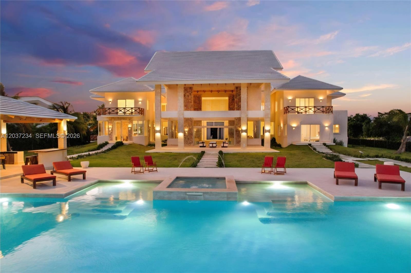 A large two-story house with a pool, hot tub, and red lounge chairs at sunset — 0 Lush greenery, FL, FL