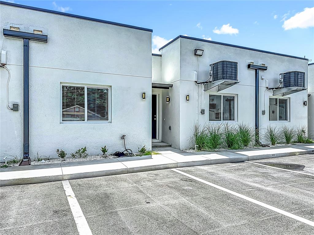 A modern, single-story white stucco building exterior with a parking lot in the foreground — 326 S GROSSE AVENUE UNIT 2, TARPON SPRINGS, FL