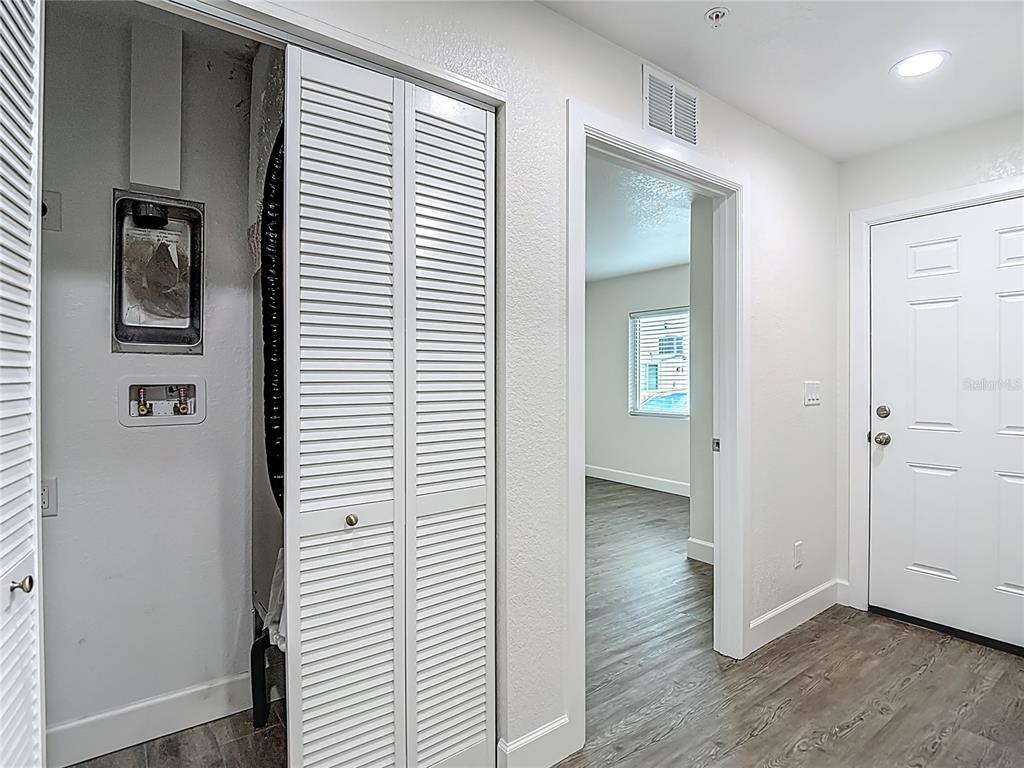 A hallway features a louvered closet door, a doorway to a room, and an entry door — 326 S GROSSE AVENUE UNIT 2, TARPON SPRINGS, FL
