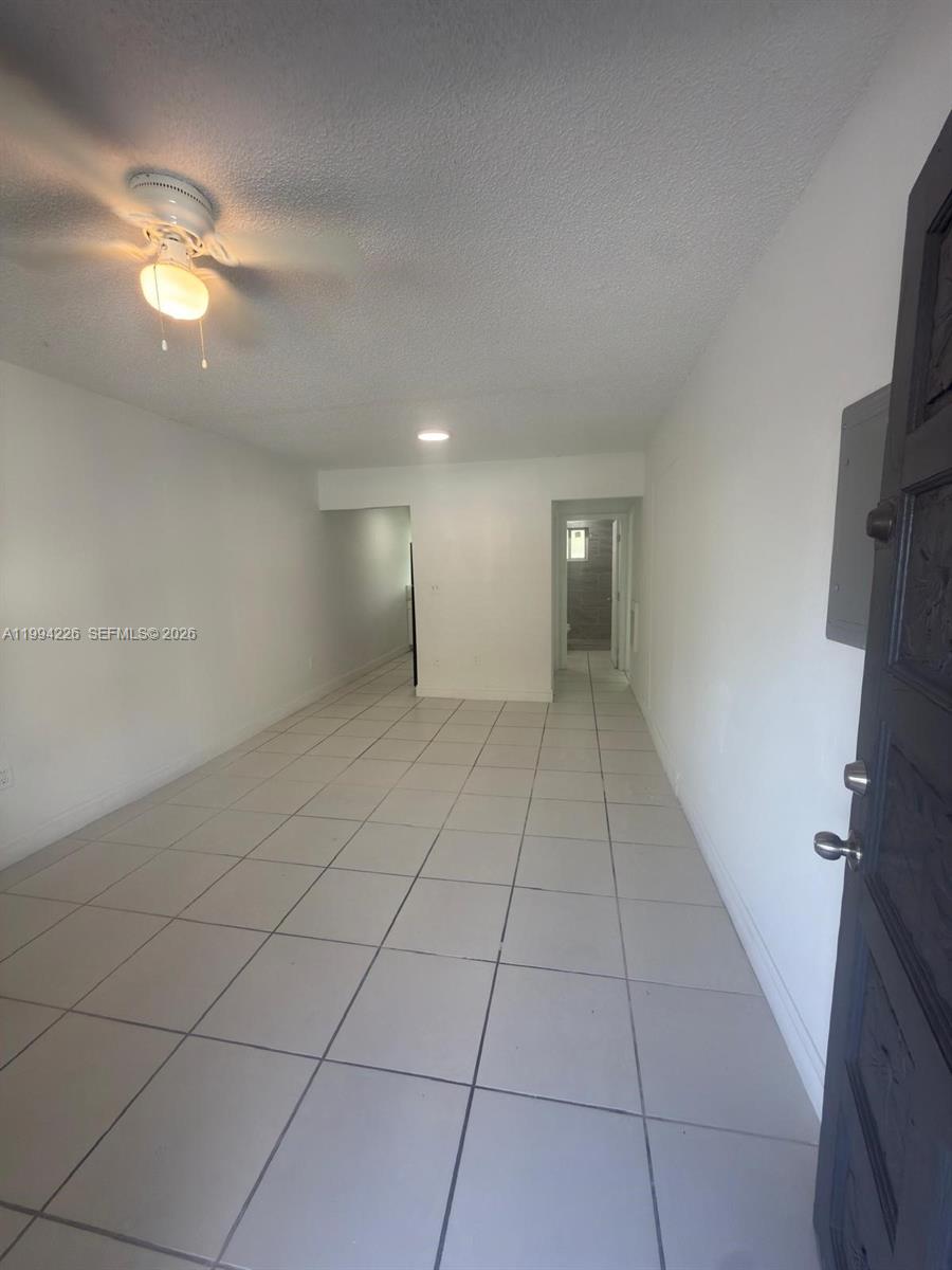 This room features white walls, a ceiling fan, and light-colored tile flooring — 2622 NW 24th St # 3B, Miami FL 33142, MIAMI, FL