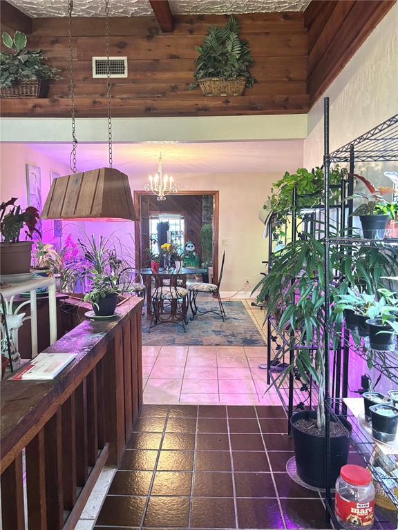 An interior view shows a tiled entryway leading to a dining area with wood paneling — 6 FAIRGREEN AVENUE, NEW SMYRNA BEACH, FL