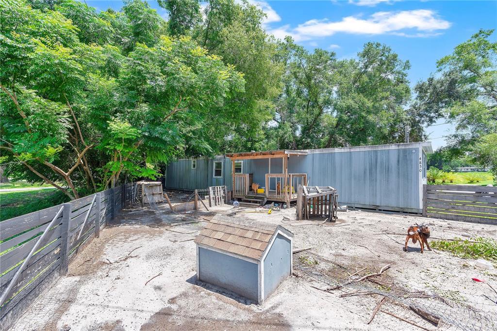 A mobile home with a small wooden porch sits on a dirt lot with fencing — 4850 W PONKAN ROAD, APOPKA, FL