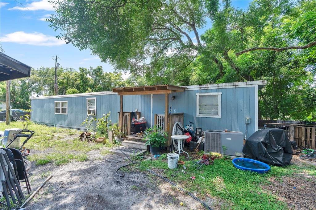 A blue mobile home with a small wooden porch sits on a dirt lot — 4850 W PONKAN ROAD, APOPKA, FL