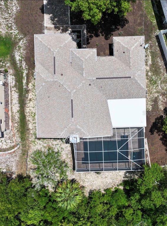 An aerial view shows a house with a shingled roof and a screened-in swimming pool — 5137 MONTFORD CIRCLE, SPRING HILL, FL