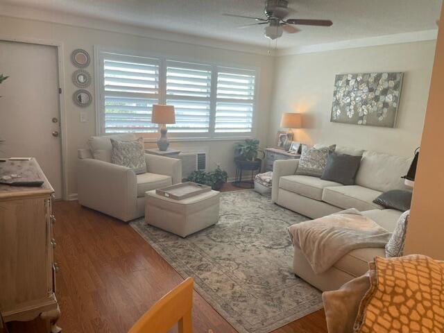 A living room features a white sofa, an armchair with an ottoman, and hardwood floors — 620 W Horizons W # 207, Boynton Beach FL 33435, BOYNTON BEACH, FL