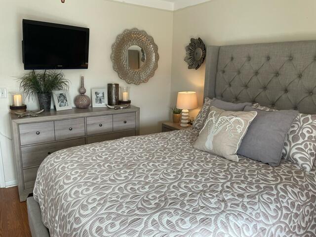A bedroom features a tufted gray headboard, a patterned bedspread, and a wooden dresser — 620 W Horizons W # 207, Boynton Beach FL 33435, BOYNTON BEACH, FL