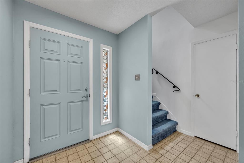An entryway features a light blue door, a stained glass sidelight, and carpeted stairs — 497 OAK HAVEN DRIVE UNIT 497, ALTAMONTE SPRINGS, FL