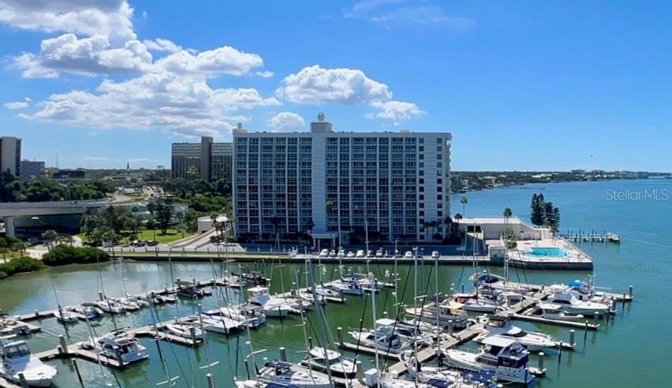 An aerial view shows a large apartment building overlooking a marina filled with boats — 100 PIERCE STREET UNIT 1001, CLEARWATER, FL