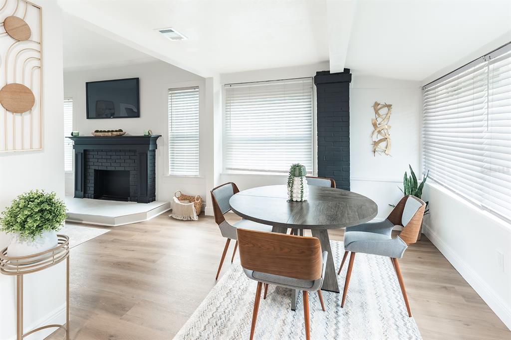 A dining area features a round wooden table, modern chairs, and a black brick fireplace — 4324 EMERSON AVENUE S, ST PETERSBURG, FL