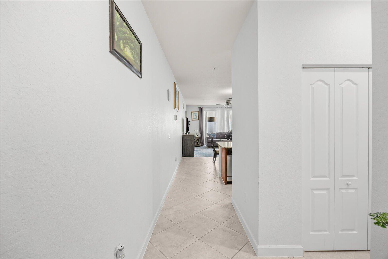 A tiled hallway leads from the foreground toward an open-concept living area and kitchen — 9500 SW Otter Lane, Stuart FL 34997, STUART, FL