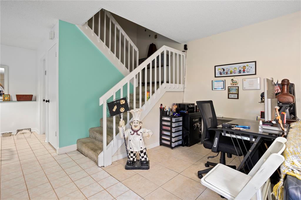 A home office area features a staircase, tiled flooring, and a chef statue — 5284 WILLOW COURT UNIT 508, ORLANDO, FL