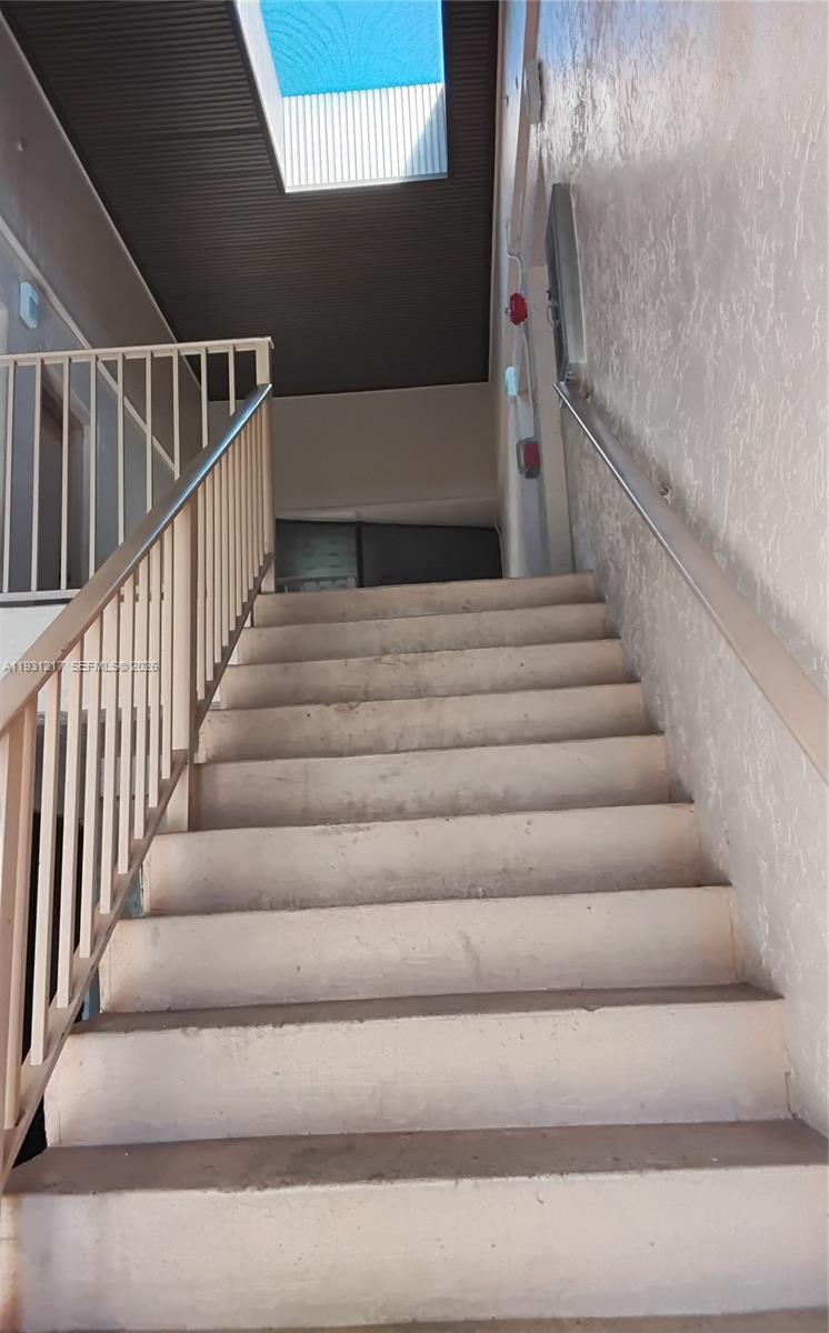 An outdoor concrete staircase with metal railings leads upward toward a covered landing — 5901 Washington St # 251, Hollywood FL 33023, HOLLYWOOD, FL