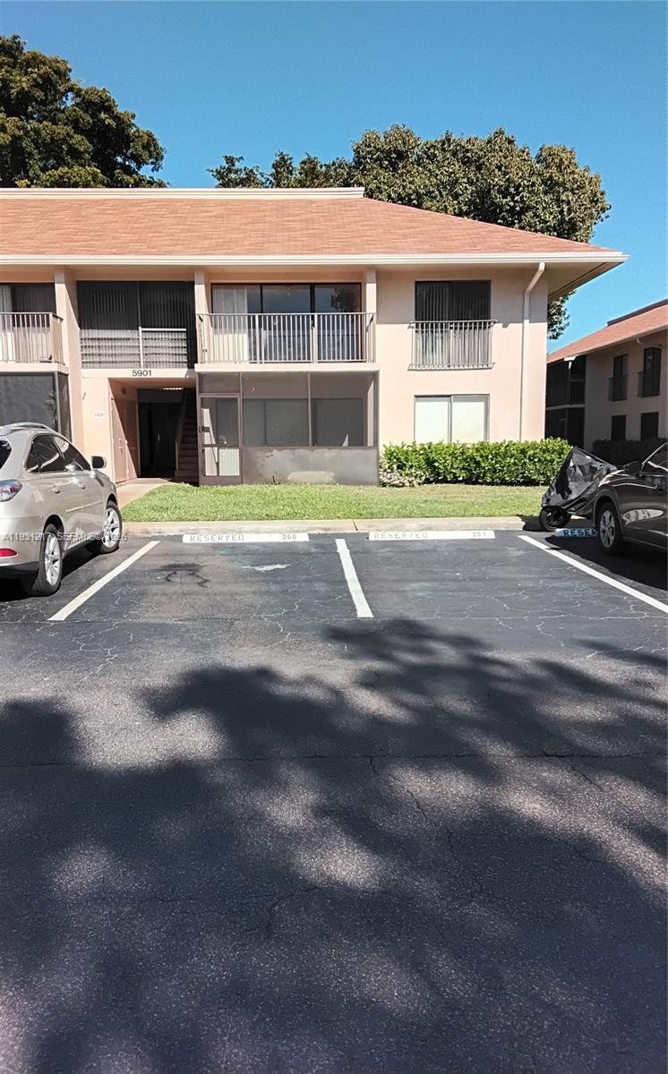 A two-story apartment building exterior features a parking lot with two reserved spaces in front — 5901 Washington St # 251, Hollywood FL 33023, HOLLYWOOD, FL