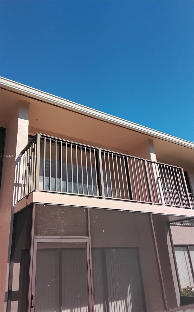 A view of a building exterior featuring a second-story balcony with metal railings — 5901 Washington St # 251, Hollywood FL 33023, HOLLYWOOD, FL