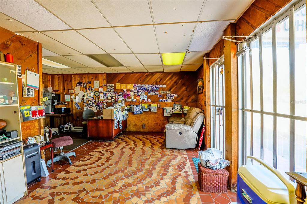 A room with wood-paneled walls, a patterned tile floor, a desk, and a recliner — 133 W STUART AVENUE, LAKE WALES, FL