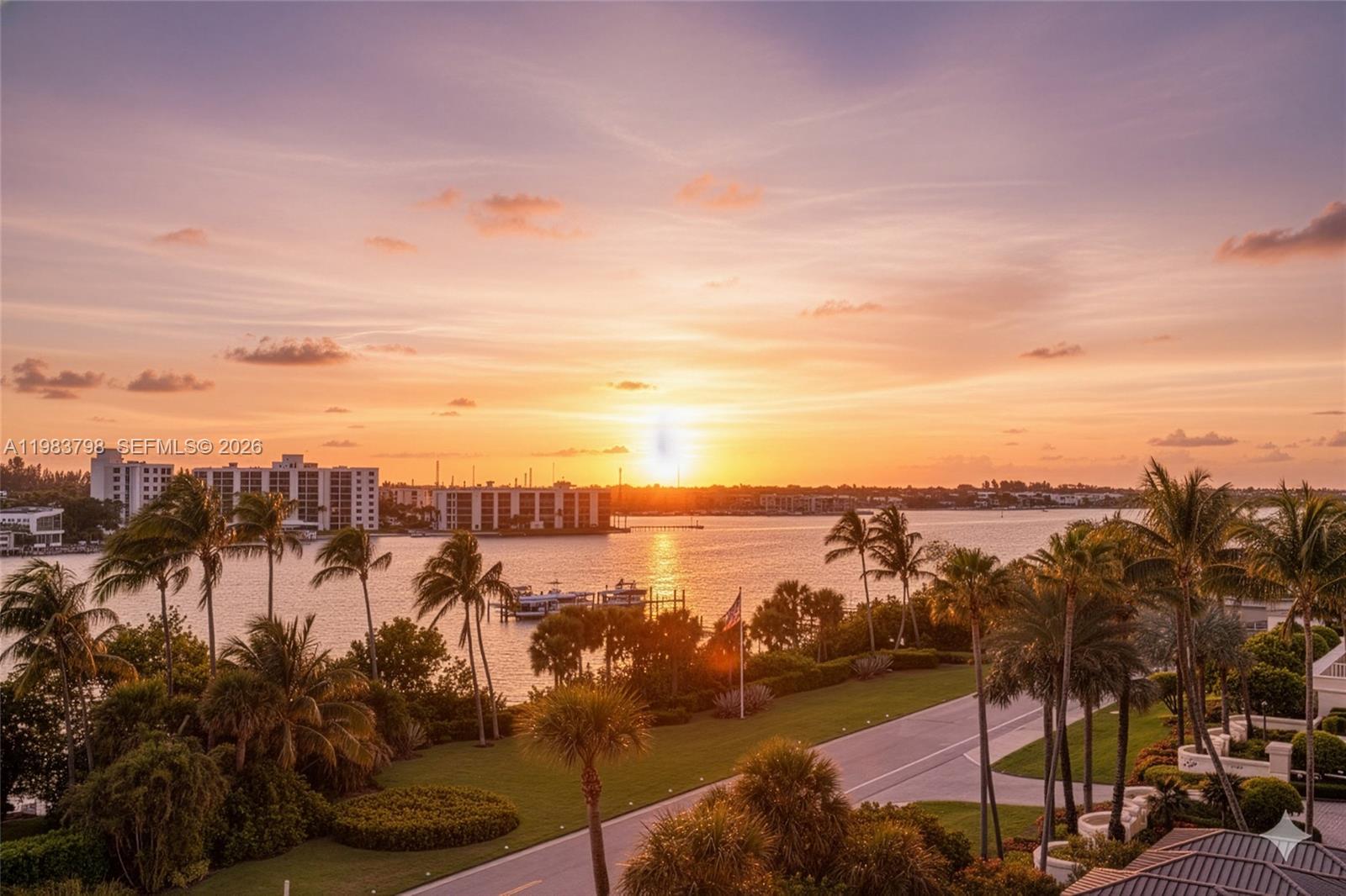 An elevated view of a sunset over a bay with palm trees and buildings — 19670 Beach Rd # A601, Tequesta FL 33469, TEQUESTA, FL