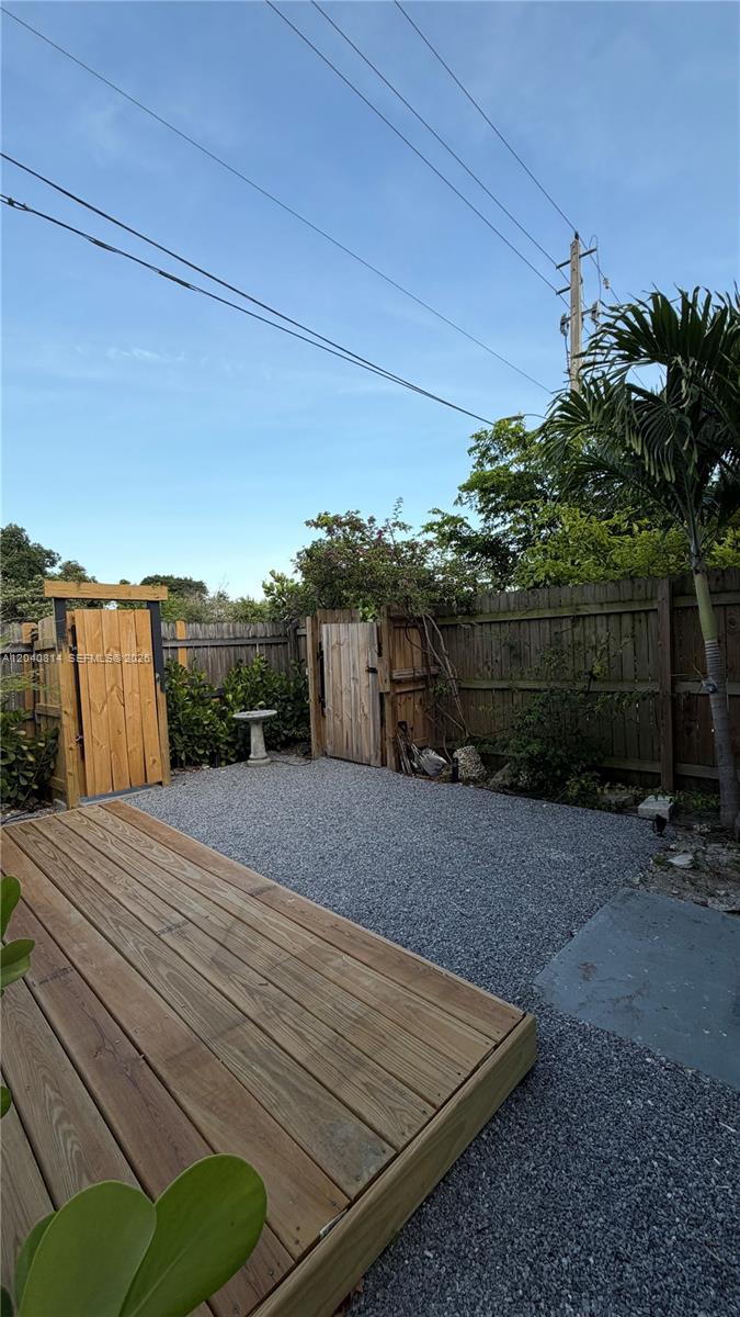 A wooden deck sits next to a gravel patio area enclosed by a wooden fence — 7025 NW 5th Ave # 2, Miami FL 33150, MIAMI, FL