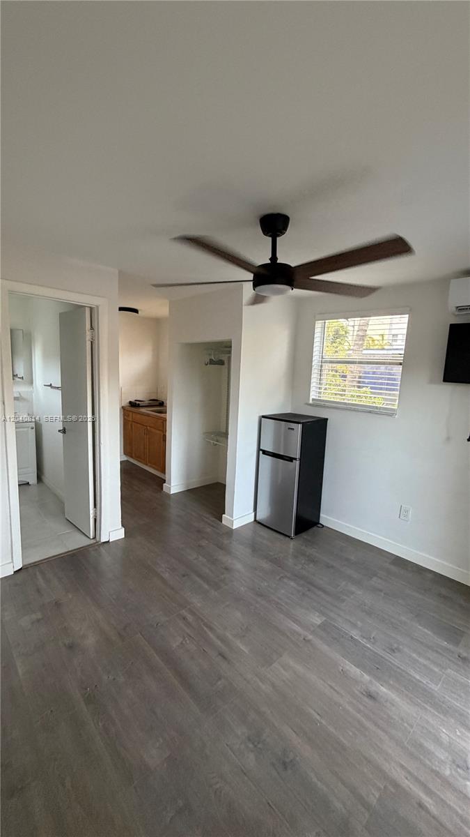 A small room features wood-look flooring, a ceiling fan, a mini-fridge, and an attached bathroom — 7025 NW 5th Ave # 2, Miami FL 33150, MIAMI, FL