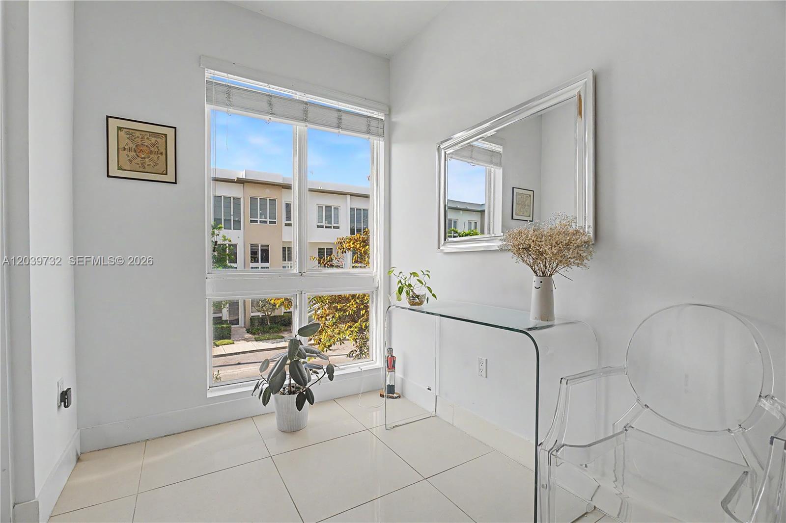 A bright room features a glass console table, a clear chair, and a large window — 10260 NW 63 Terrace # 213, Miami FL 33178, MIAMI, FL