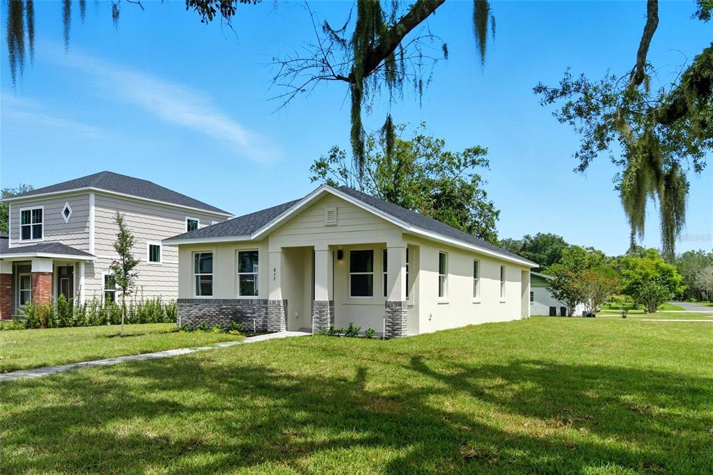 A single-story house with light-colored siding, a stone base, and a covered front porch — 817 S LOCUST AVENUE, SANFORD, FL