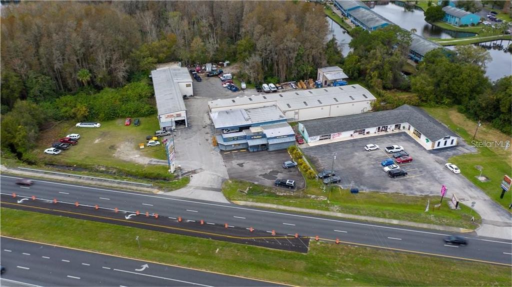 An aerial view shows a commercial property with multiple buildings, parking lots, and a highway — 1635 DALE MABRY HIGHWAY, LUTZ, FL