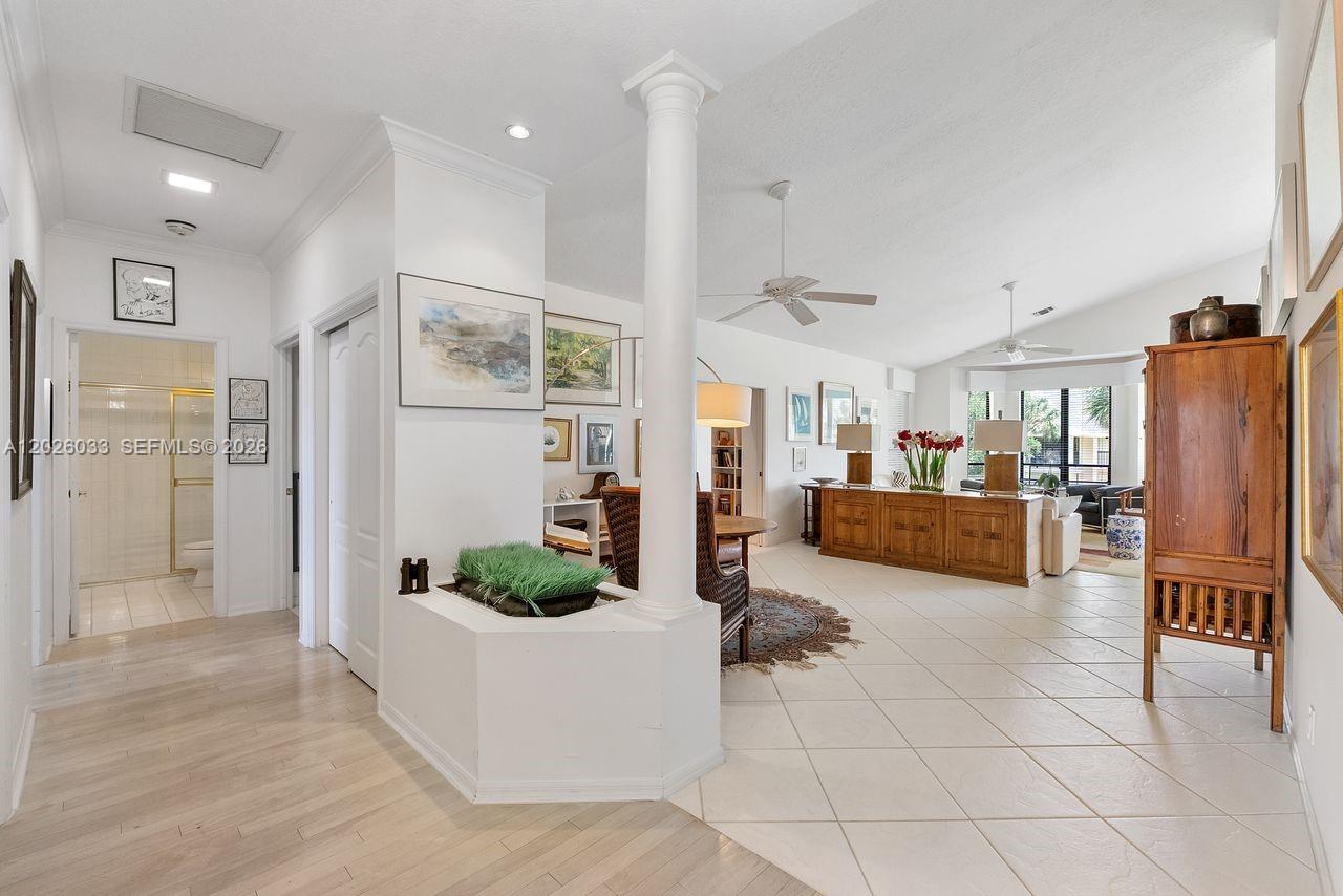 A hallway features light wood flooring, a red runner rug, and a tiered wooden cabinet — 10411 SE Terrapin Place # 203, Jupiter FL 33469, JUPITER, FL