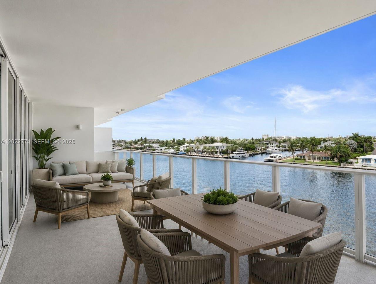 A spacious balcony features outdoor seating, a dining table, and a view of the water — 407 N Riverside # 402, Pompano Beach FL 33062, POMPANO BEACH, FL