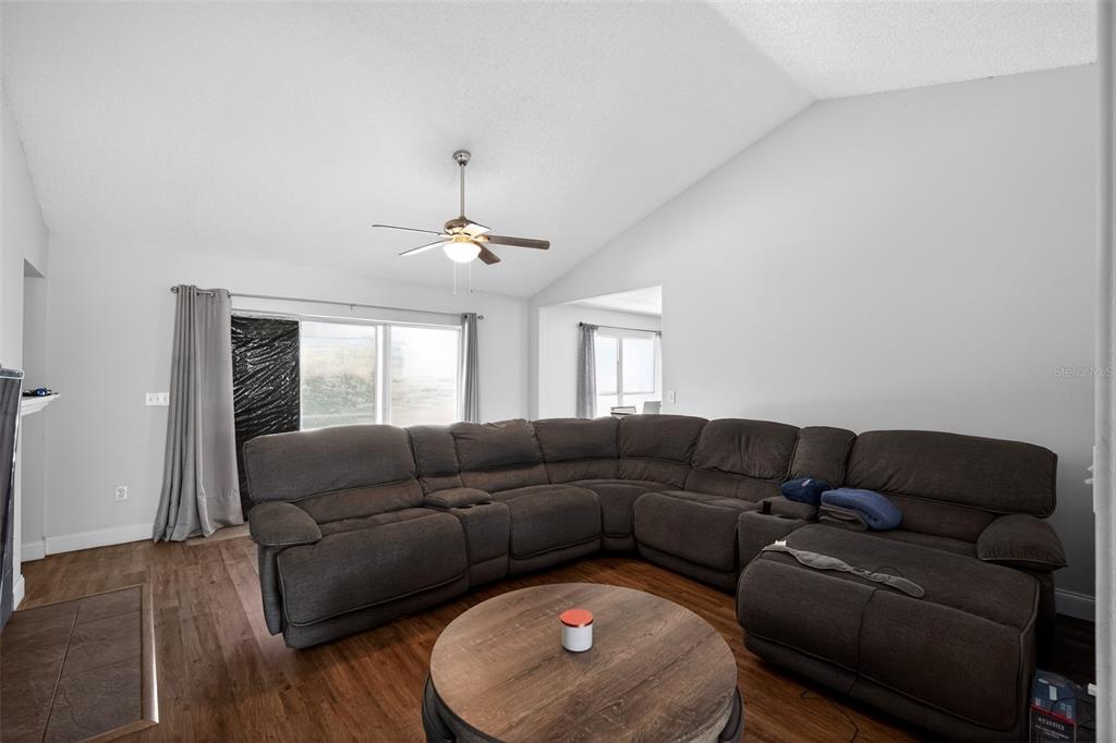 A living room features a large sectional sofa, a round coffee table, and a ceiling fan — 906 LAKEMONT HILLS BOULEVARD, BRANDON, FL
