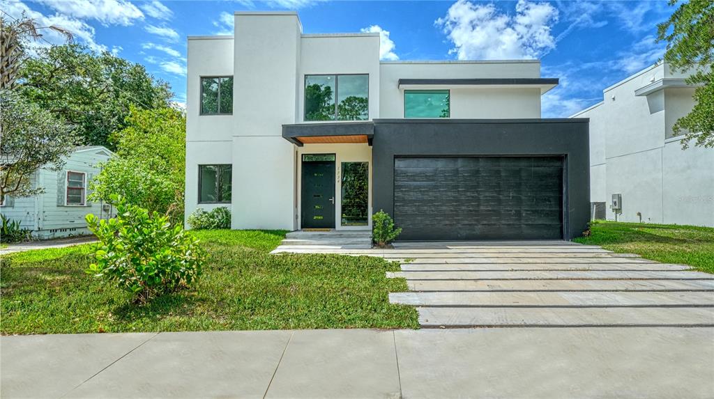 A modern two-story house features a white facade, a black garage, and a concrete driveway — 1734 WISCONSIN LANE, SARASOTA, FL