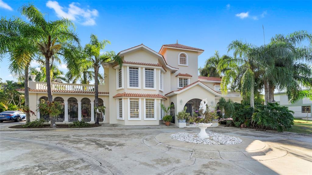 A two-story house with a circular driveway, a fountain, and palm trees in the front yard — Carr. 311 km 0.3 BO. BAJURA, CABO ROJO, PR