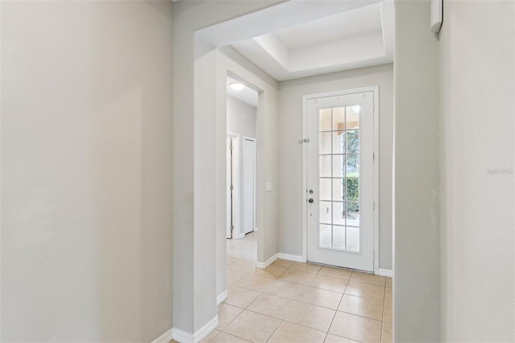 A tiled entryway features a white French door and a recessed tray ceiling — 4627 BLUE MAJOR DRIVE, WINDERMERE, FL