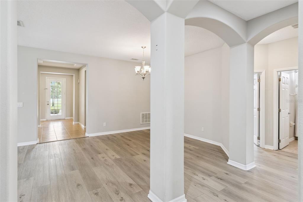 An interior view shows a dining area with light wood flooring and an arched entryway — 4627 BLUE MAJOR DRIVE, WINDERMERE, FL