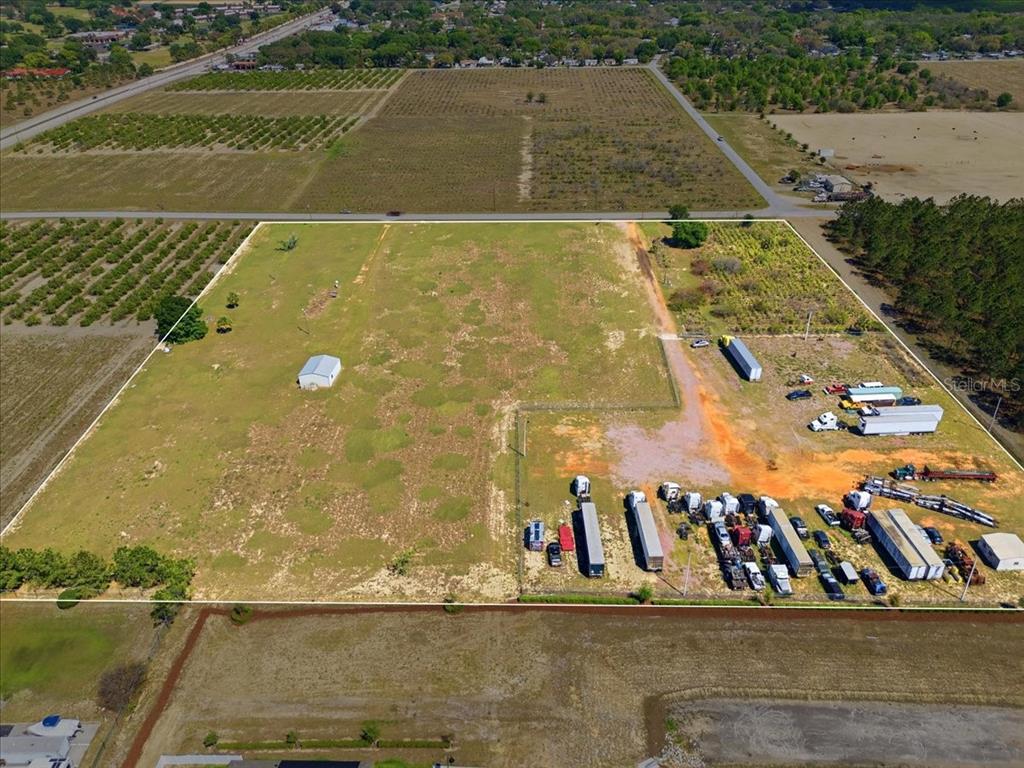 An aerial view shows a large, rectangular plot of land with a small building and vehicles — 186 LEWIS GRIFFIN ROAD, LAKE WALES, FL
