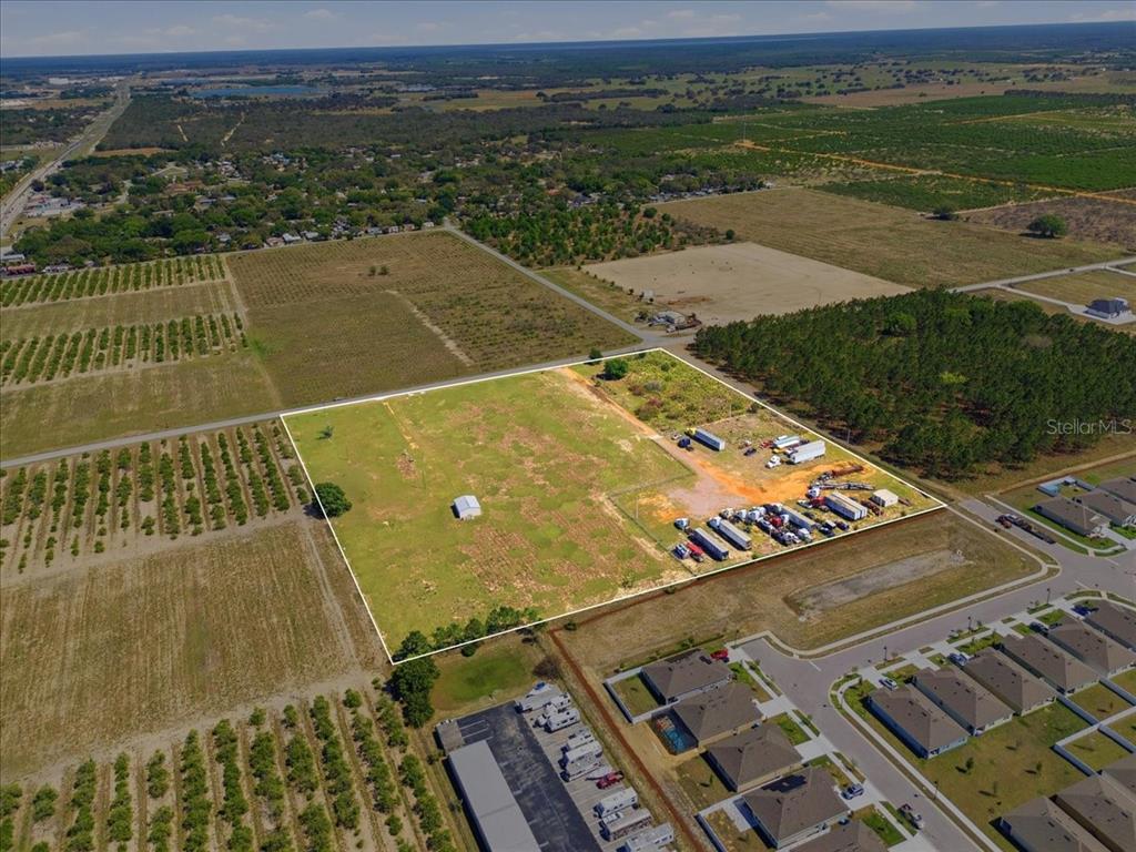 An aerial view shows a large, rectangular vacant lot with a small building and vehicles — 186 LEWIS GRIFFIN ROAD, LAKE WALES, FL
