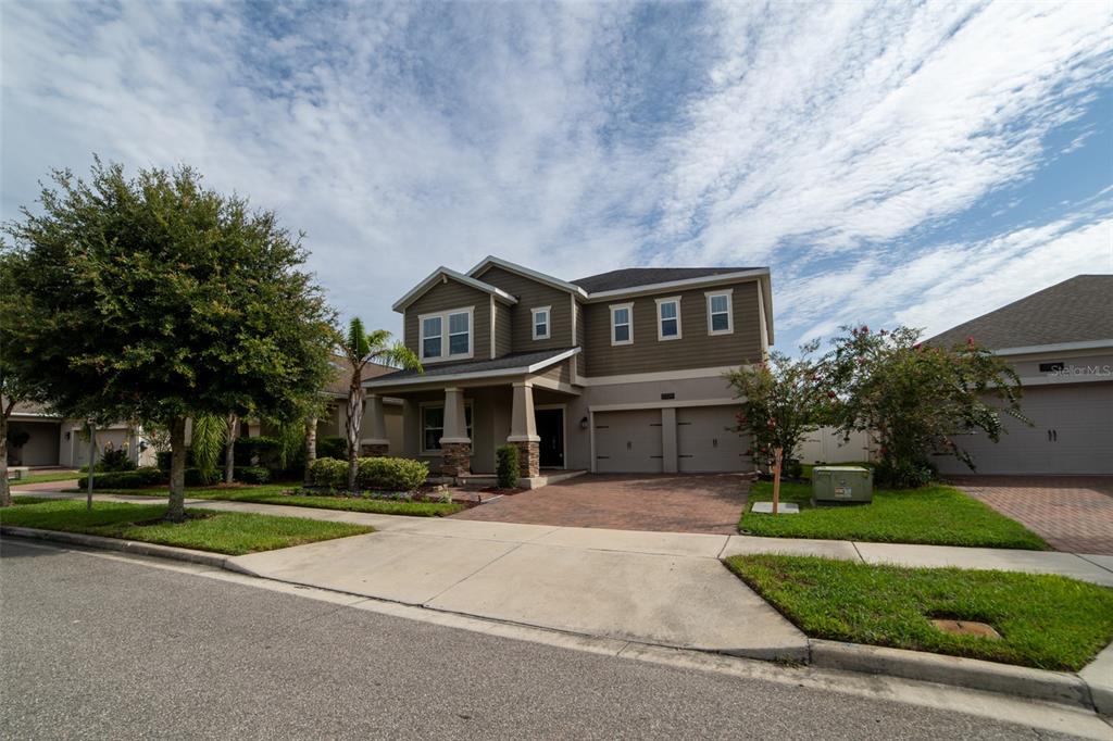 A two-story suburban house with a brown exterior, a paver driveway, and a two-car garage — 11109 SWEETGUM WOODS DRIVE, ORLANDO, FL
