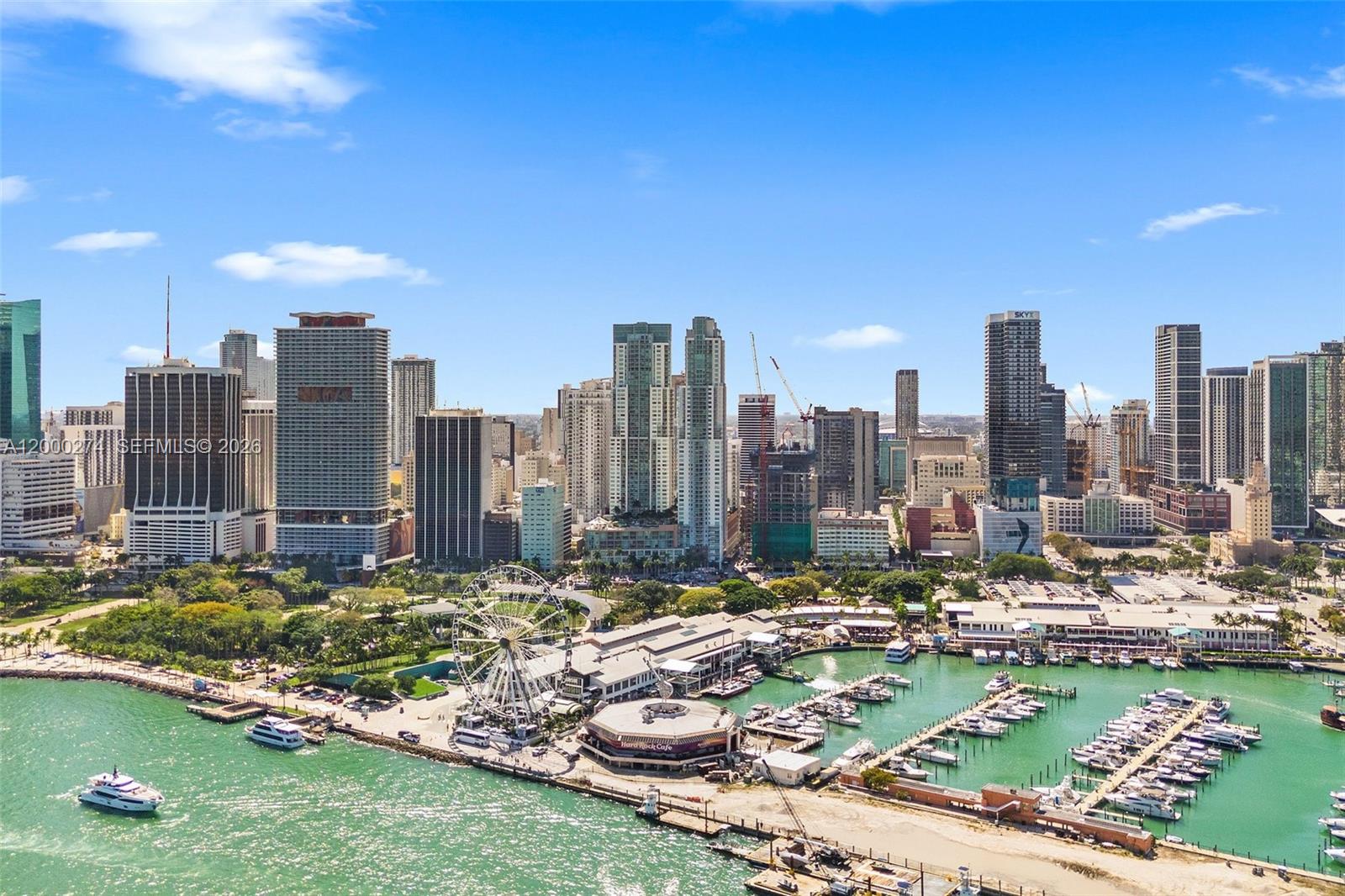 An aerial view of the Miami skyline featuring a Ferris wheel, marina, and skyscrapers — 244 Biscayne Blvd # 1709, Miami FL 33132, MIAMI, FL