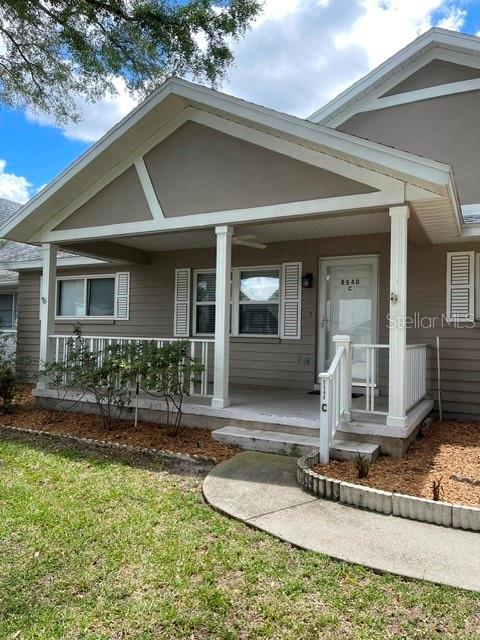 The exterior of a single-story house features a covered front porch with white railings — 8540 SW 91ST PLACE UNIT C, OCALA, FL