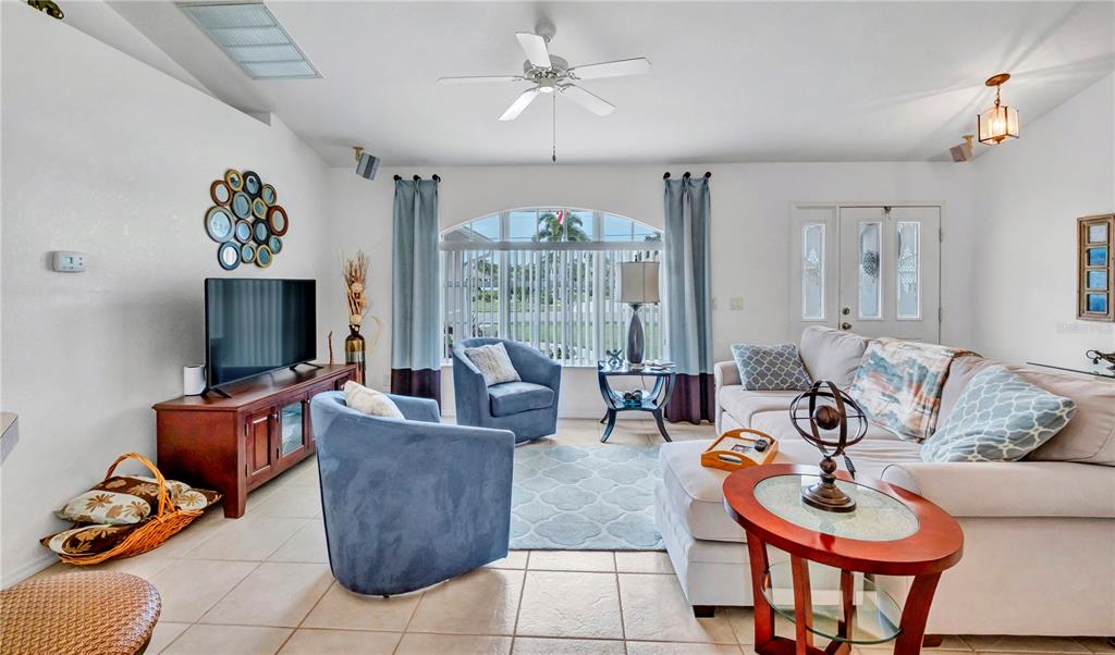 A living room features tile floors, a ceiling fan, blue armchairs, and a sectional sofa — 7360 N FICUS TREE, PUNTA GORDA, FL