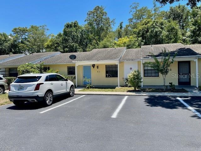 A white SUV is parked in front of a single-story residential building with yellow siding — 2780 PARK DRIVE UNIT C-3, CLEARWATER, FL