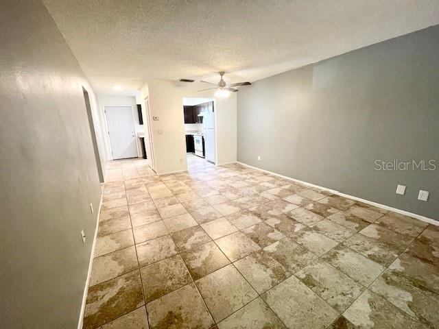 An interior view shows a tiled living area leading toward a kitchen with white appliances — 2780 PARK DRIVE UNIT C-3, CLEARWATER, FL