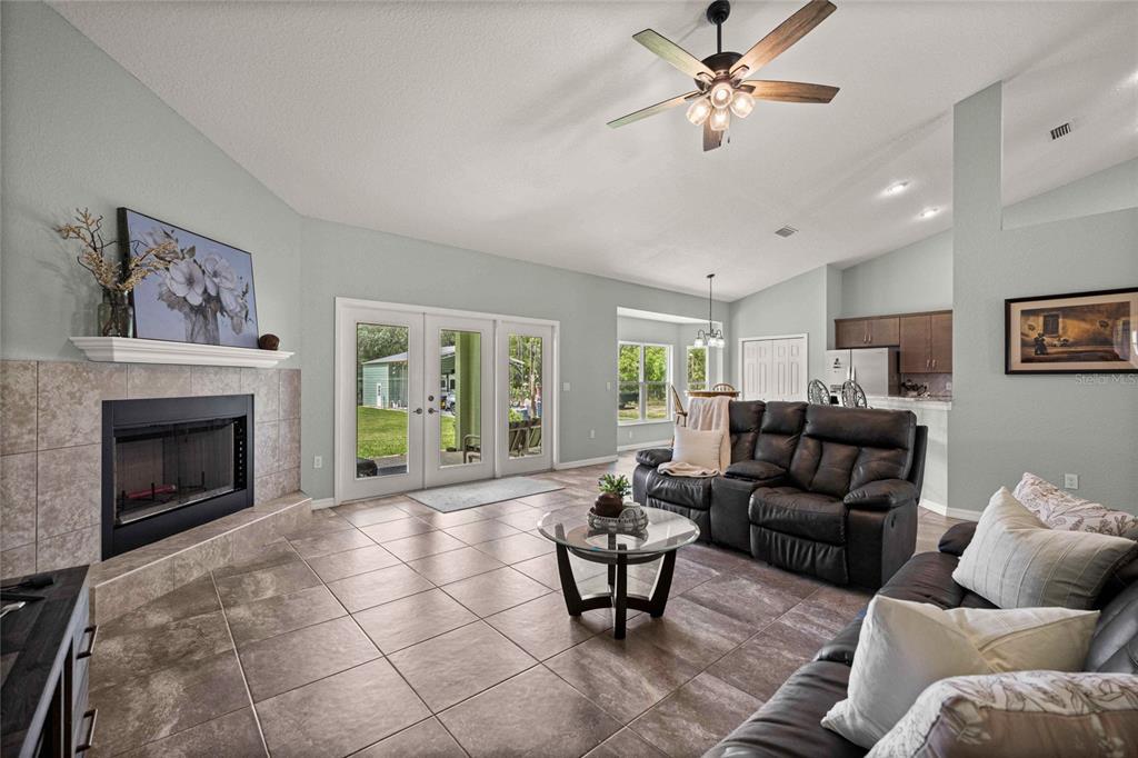 A living room features tile flooring, a fireplace, a ceiling fan, and sliding glass doors — 13130 SW 88TH STREET, DUNNELLON, FL