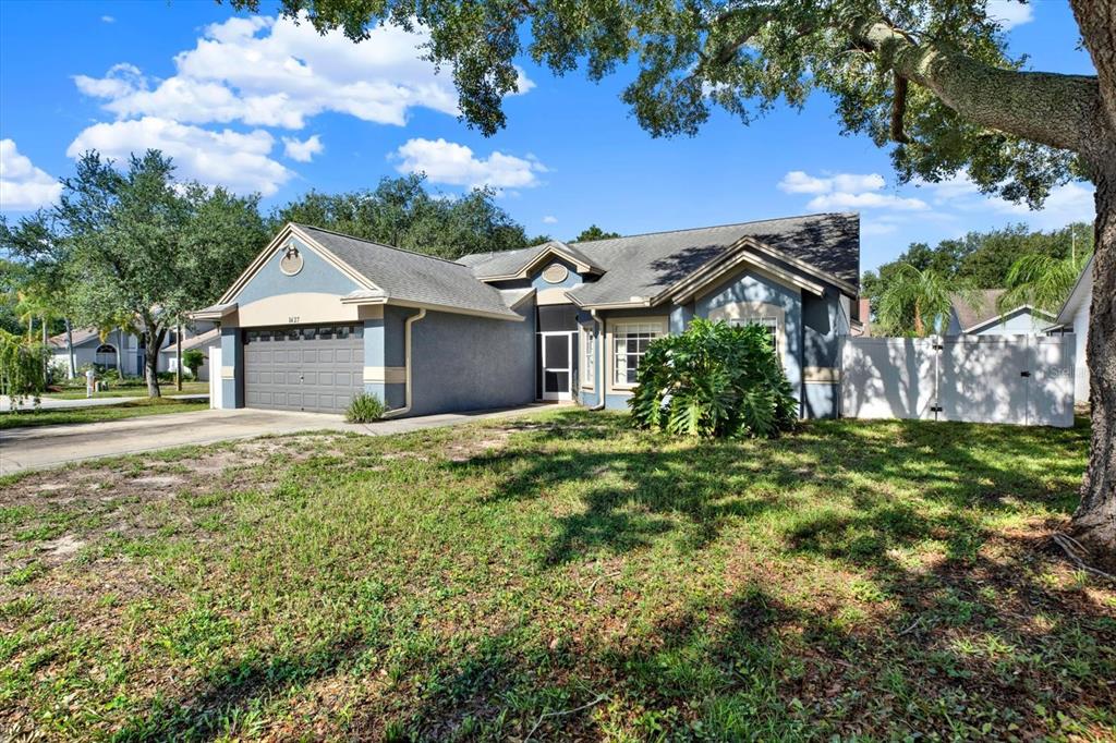 A single-story blue house with a two-car garage, a front entrance, and a grassy yard — 1427 BAY VIEW STREET, TARPON SPRINGS, FL