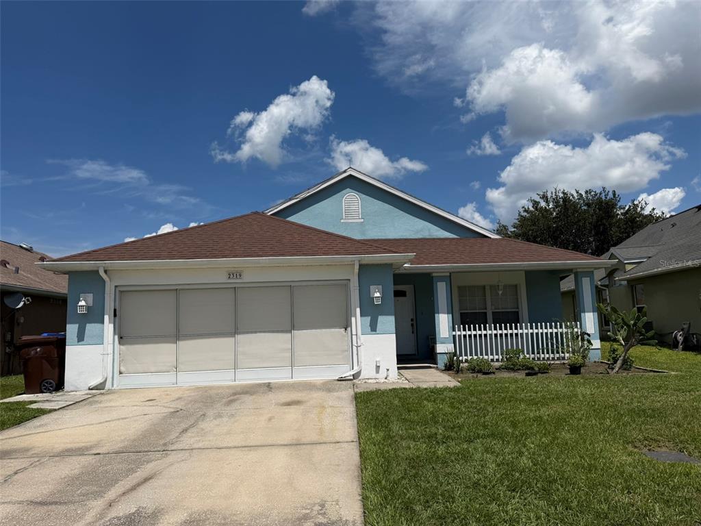 A single-story house with a blue exterior, brown roof, and a two-car garage — 2319 LILY PAD LANE, KISSIMMEE, FL