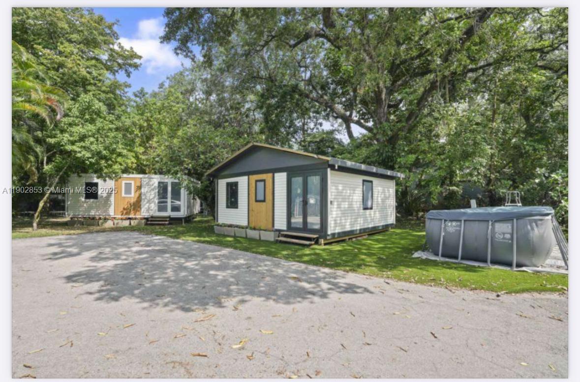 Two small modular homes sit on a gravel lot next to an above-ground pool — 3460 70th Avenue NE, Naples FL 34120, NAPLES, FL