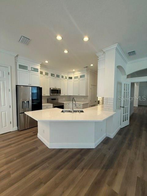 A modern kitchen features white cabinetry, stainless steel appliances, and a large central island — 912 WATERSIDE DRIVE, CELEBRATION, FL