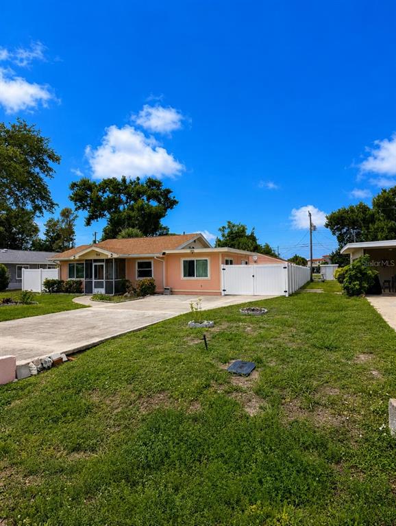 A peach-colored single-story house features a concrete driveway and a white vinyl privacy fence — 733 LAUREL AVENUE, VENICE, FL