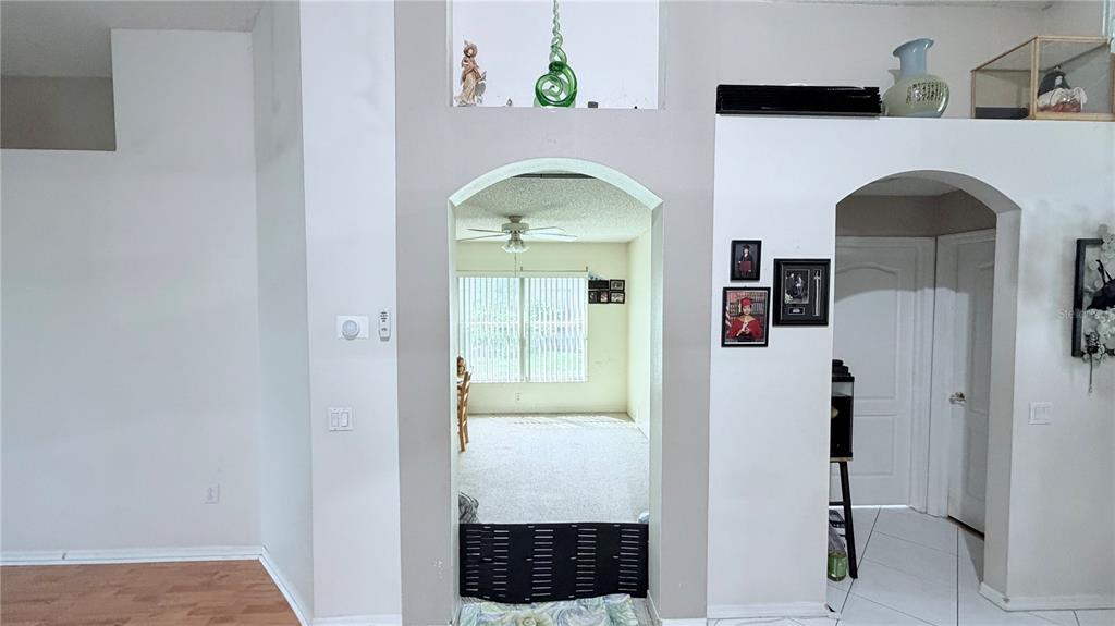 An arched doorway leads from a tiled entryway into a carpeted room with a ceiling fan — 8503 PRINGLE WAY, TAMPA, FL